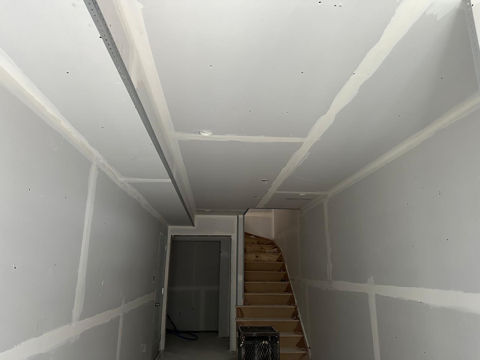 Drywall walls and ceiling near a staircase